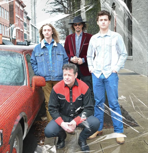 A group of people standing next to a car.
